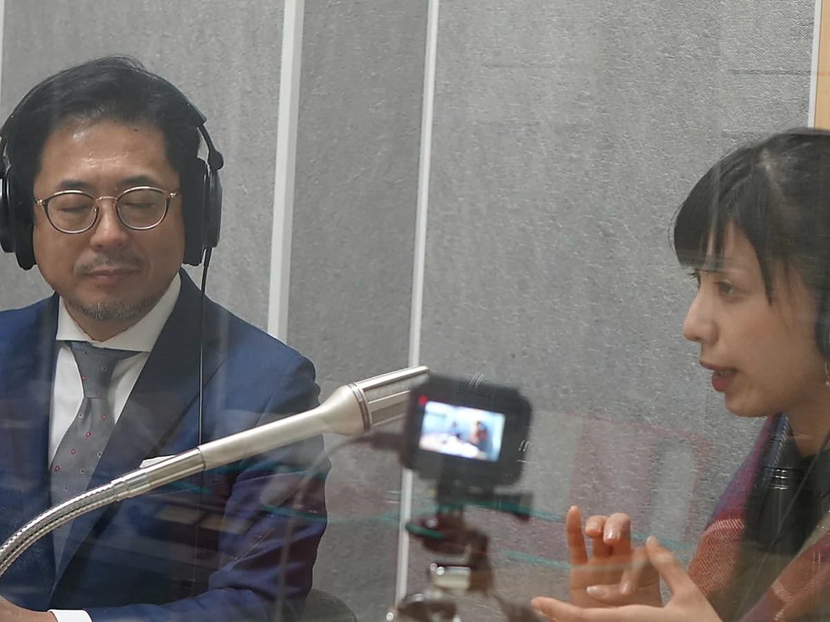 本棚の前で3つの選定基準をメモするひとり社長
