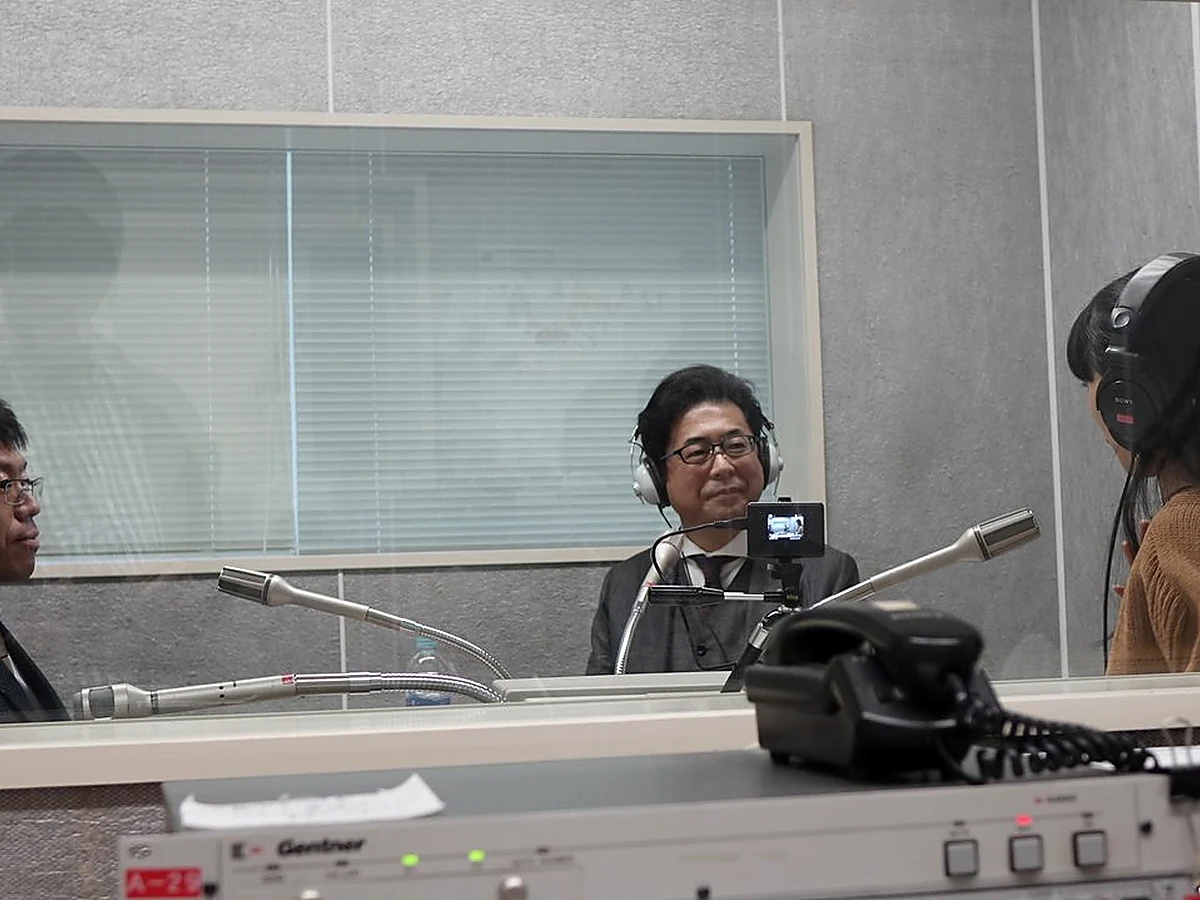 eye-level portrait framing of a friendly Japanese business owner with a calm uncluttered background, no text