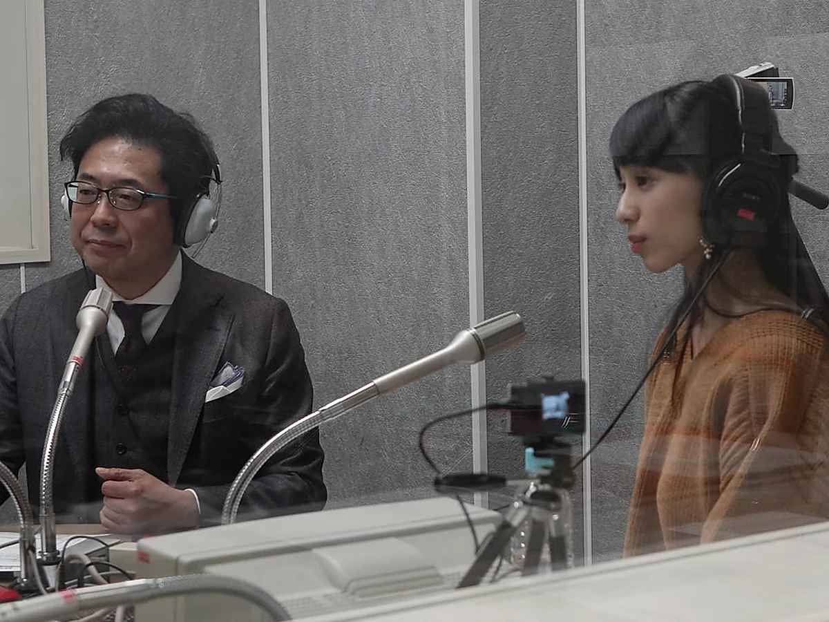 A mature Japanese speaker sharing an idea with a small attentive audience, no text